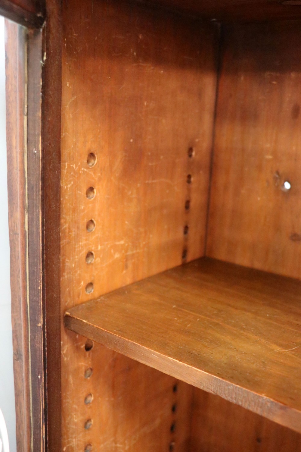 An early twentieth-century mahogany framed bookcase featuring two glazed doors decorated with the Home Office royal coat of arms stencil, supported on cabriole legs. View XX