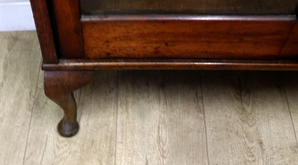 An early twentieth-century mahogany framed bookcase featuring two glazed doors decorated with the Home Office royal coat of arms stencil, supported on cabriole legs. View XXVII