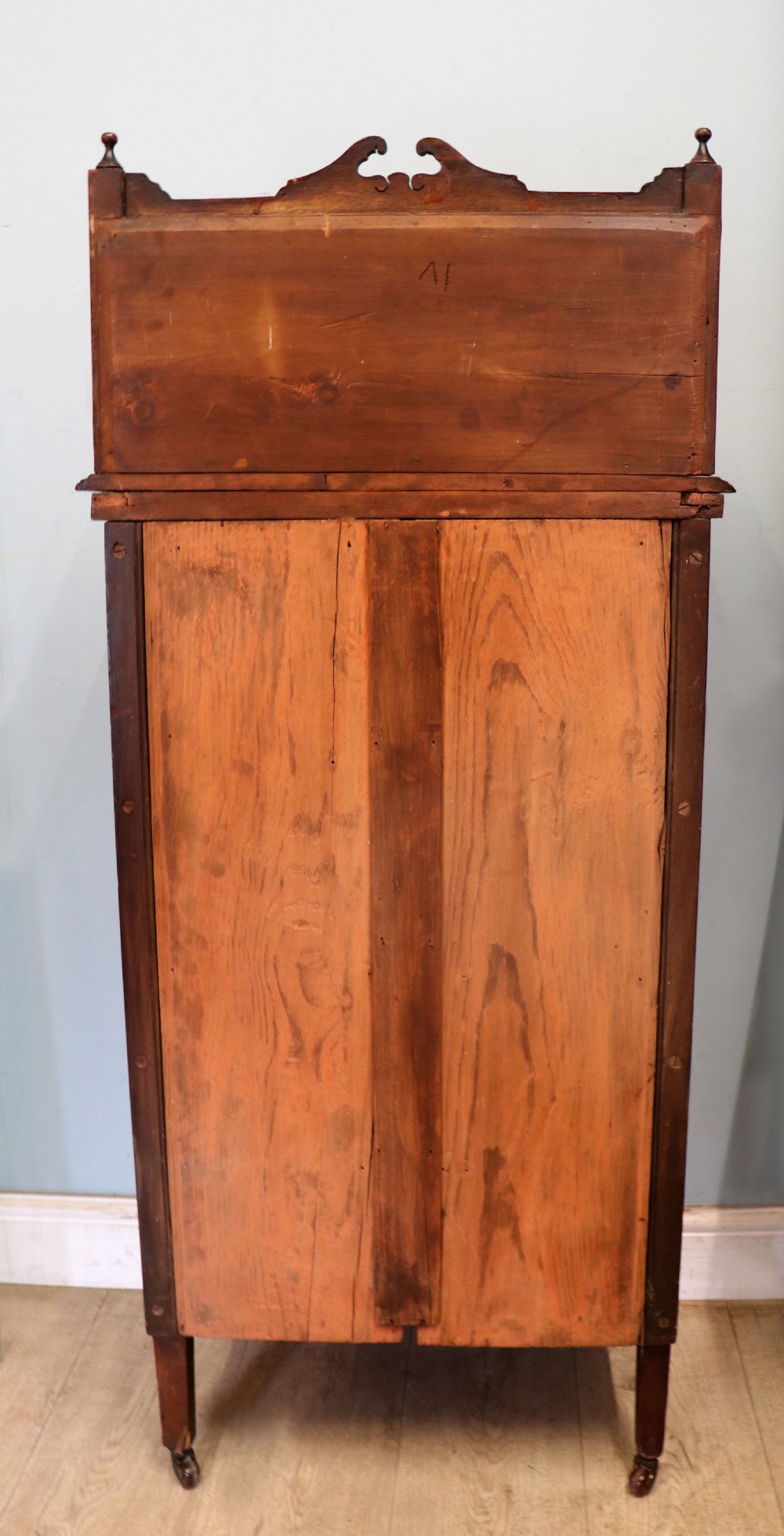 A late nineteenth-century dark hardwood music cabinet featuring floral marquetry inlay on the upper door, an oval mirror panel framed by scroll carving below, and a galleried upper shelf. View VII