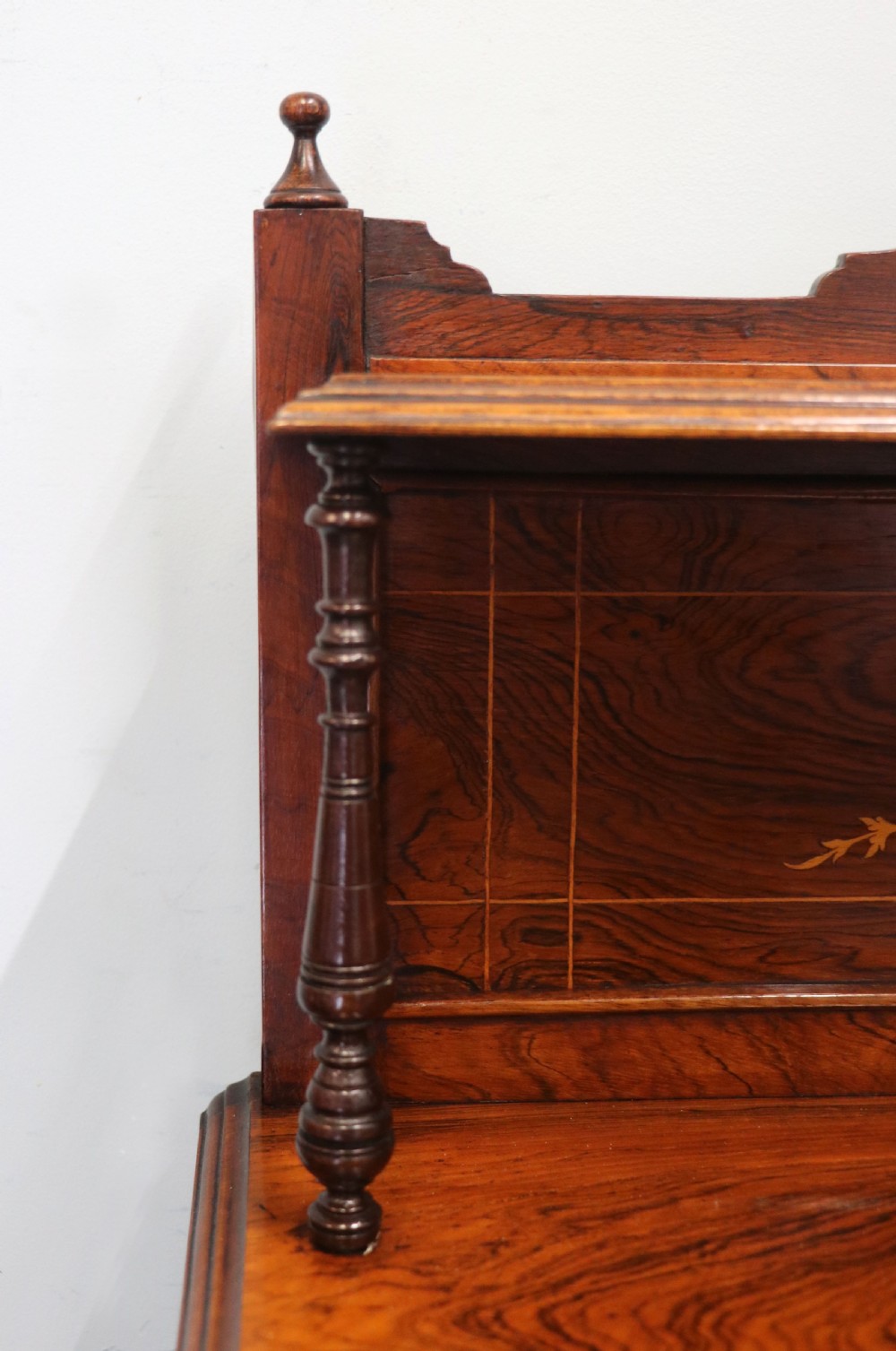 A late nineteenth-century dark hardwood music cabinet featuring floral marquetry inlay on the upper door, an oval mirror panel framed by scroll carving below, and a galleried upper shelf. View VIII