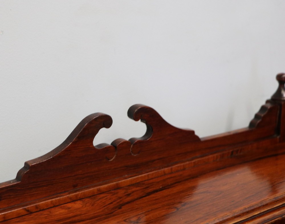 A late nineteenth-century dark hardwood music cabinet featuring floral marquetry inlay on the upper door, an oval mirror panel framed by scroll carving below, and a galleried upper shelf. View XI