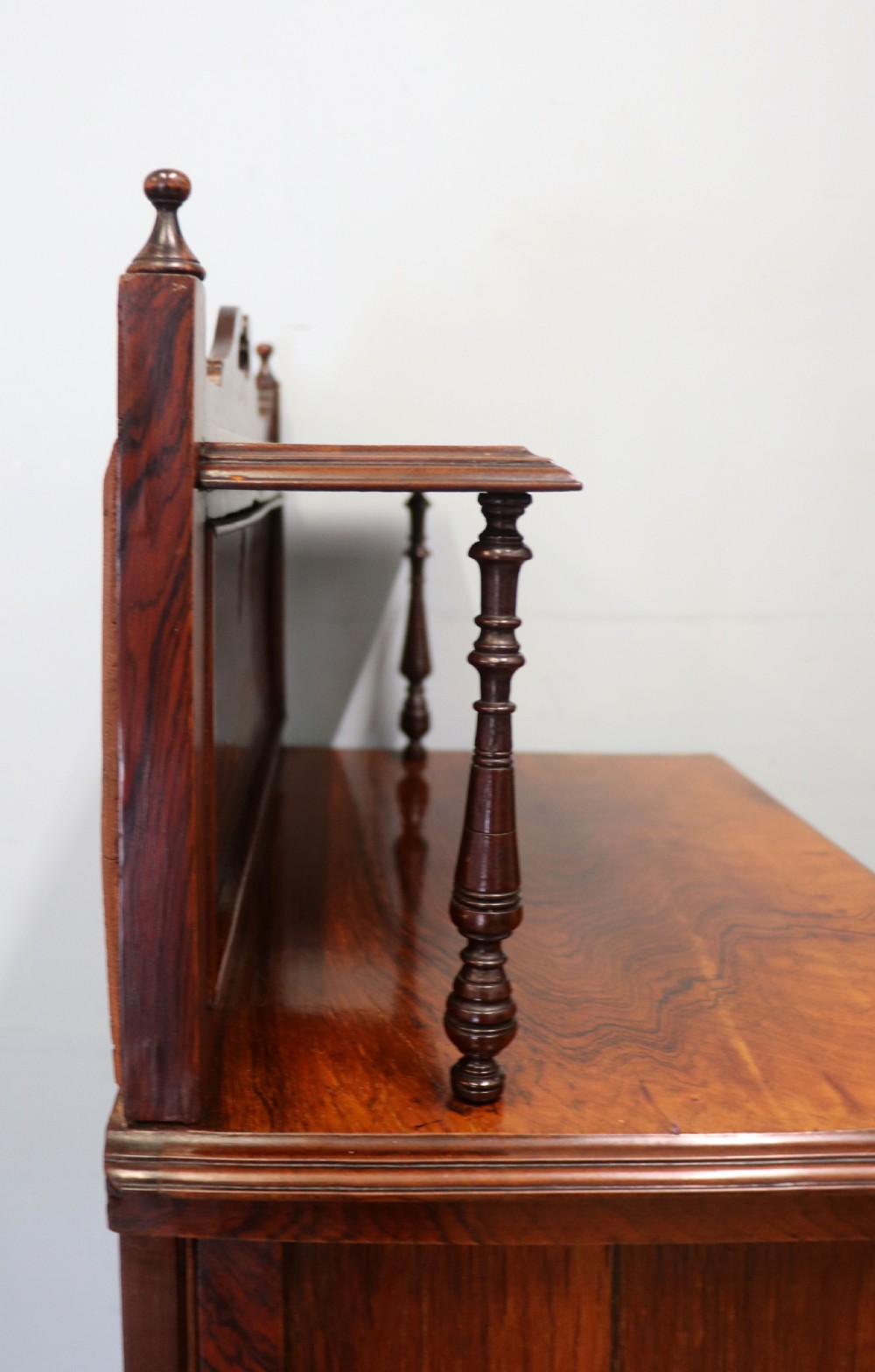 A late nineteenth-century dark hardwood music cabinet featuring floral marquetry inlay on the upper door, an oval mirror panel framed by scroll carving below, and a galleried upper shelf. View XIII