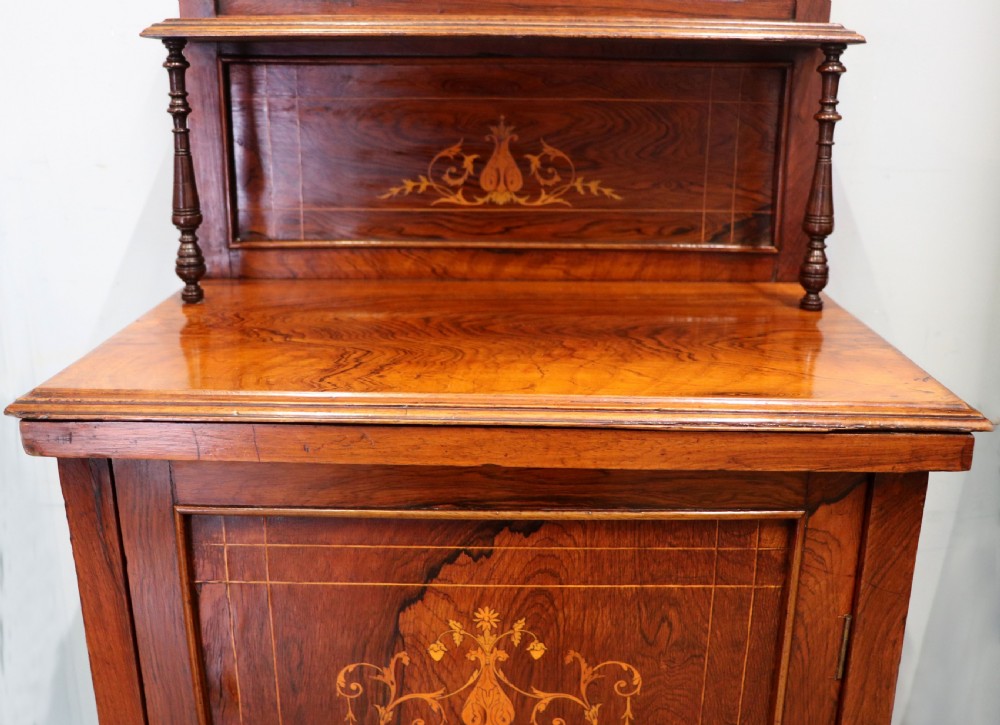 A late nineteenth-century dark hardwood music cabinet featuring floral marquetry inlay on the upper door, an oval mirror panel framed by scroll carving below, and a galleried upper shelf. View XIV