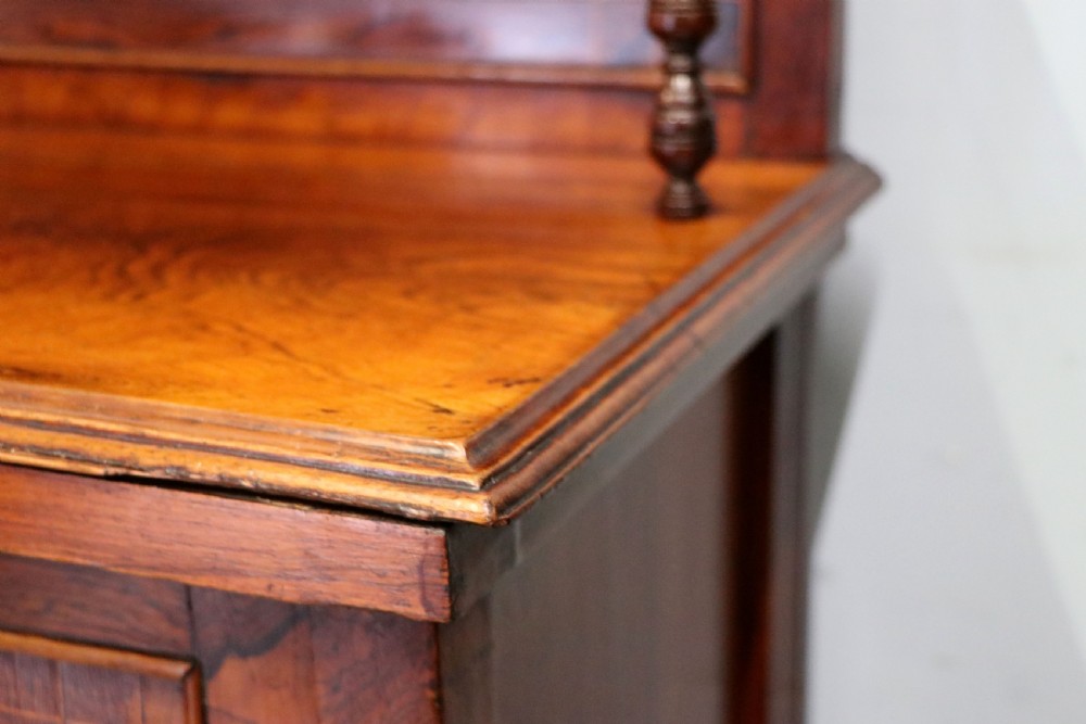A late nineteenth-century dark hardwood music cabinet featuring floral marquetry inlay on the upper door, an oval mirror panel framed by scroll carving below, and a galleried upper shelf. View XV