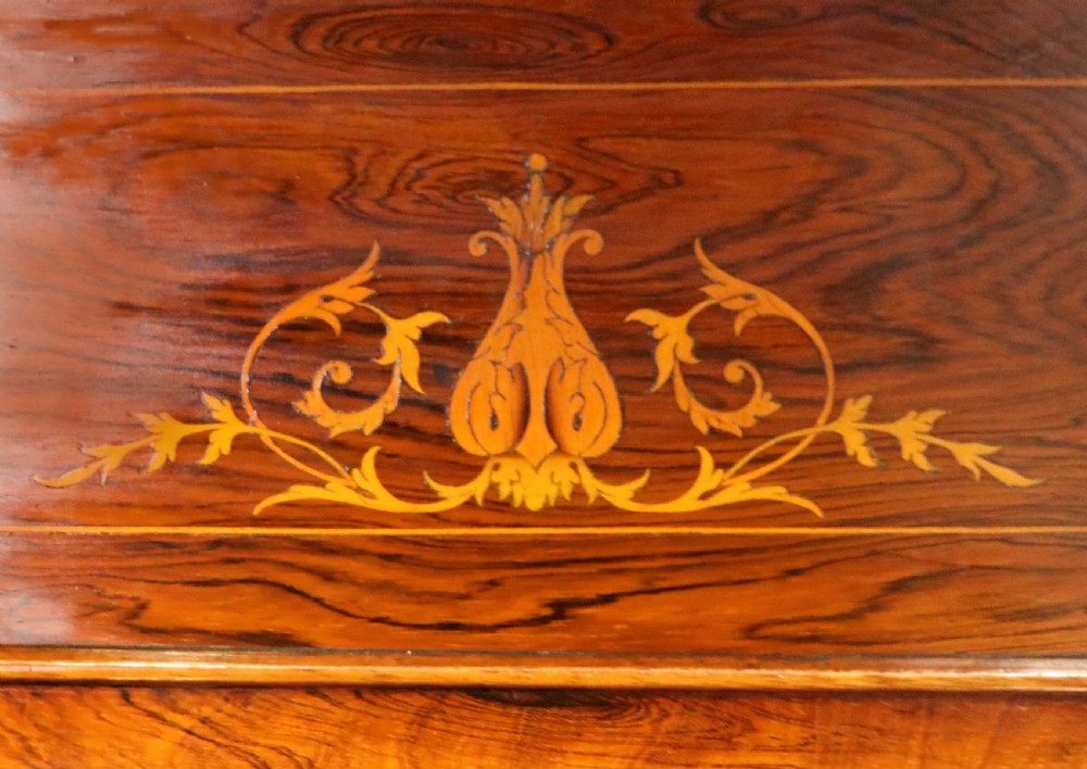 A late nineteenth-century dark hardwood music cabinet featuring floral marquetry inlay on the upper door, an oval mirror panel framed by scroll carving below, and a galleried upper shelf. View XVI