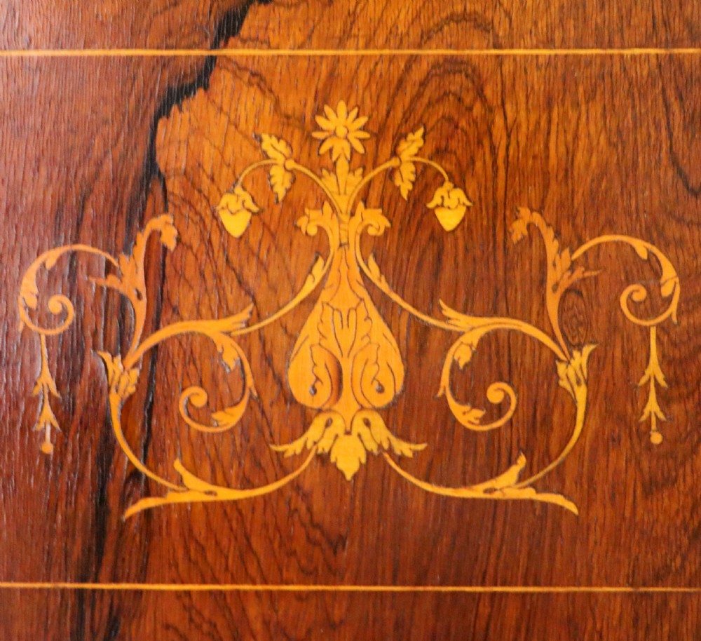 A late nineteenth-century dark hardwood music cabinet featuring floral marquetry inlay on the upper door, an oval mirror panel framed by scroll carving below, and a galleried upper shelf. View XVII