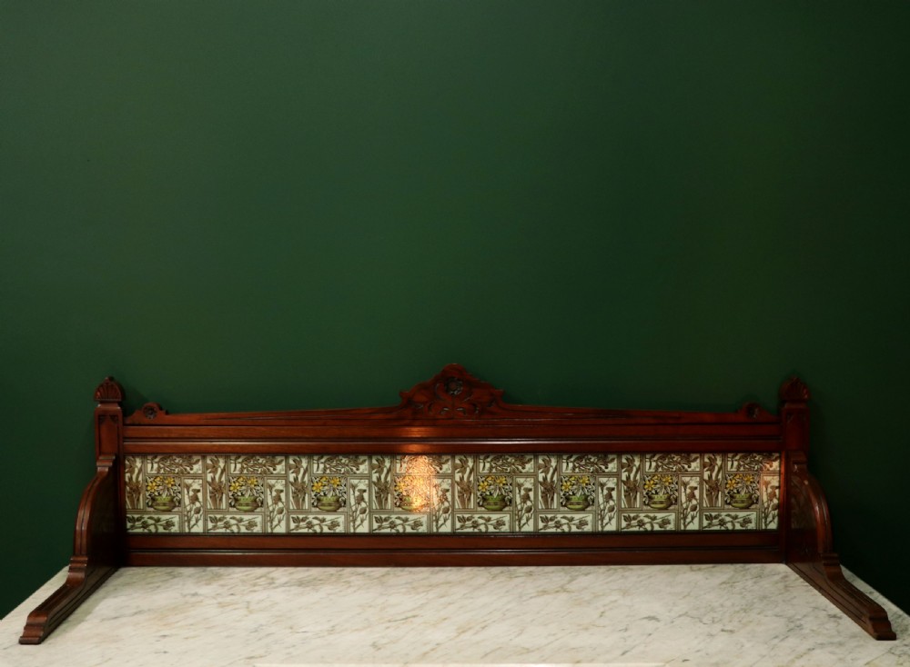 A Victorian Aesthetic Movement mahogany washstand featuring a white marble top, a tiled gallery splashback with floral motifs, two pedestal cupboards, and a central drawer. View VIII
