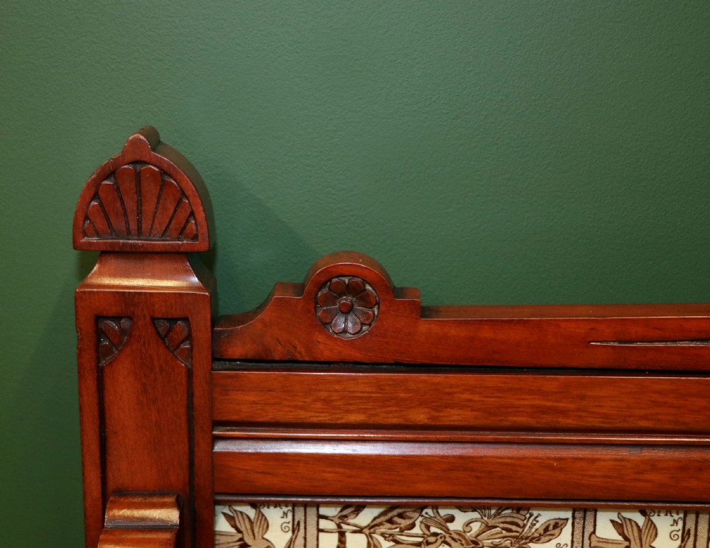 A Victorian Aesthetic Movement mahogany washstand featuring a white marble top, a tiled gallery splashback with floral motifs, two pedestal cupboards, and a central drawer. View IX