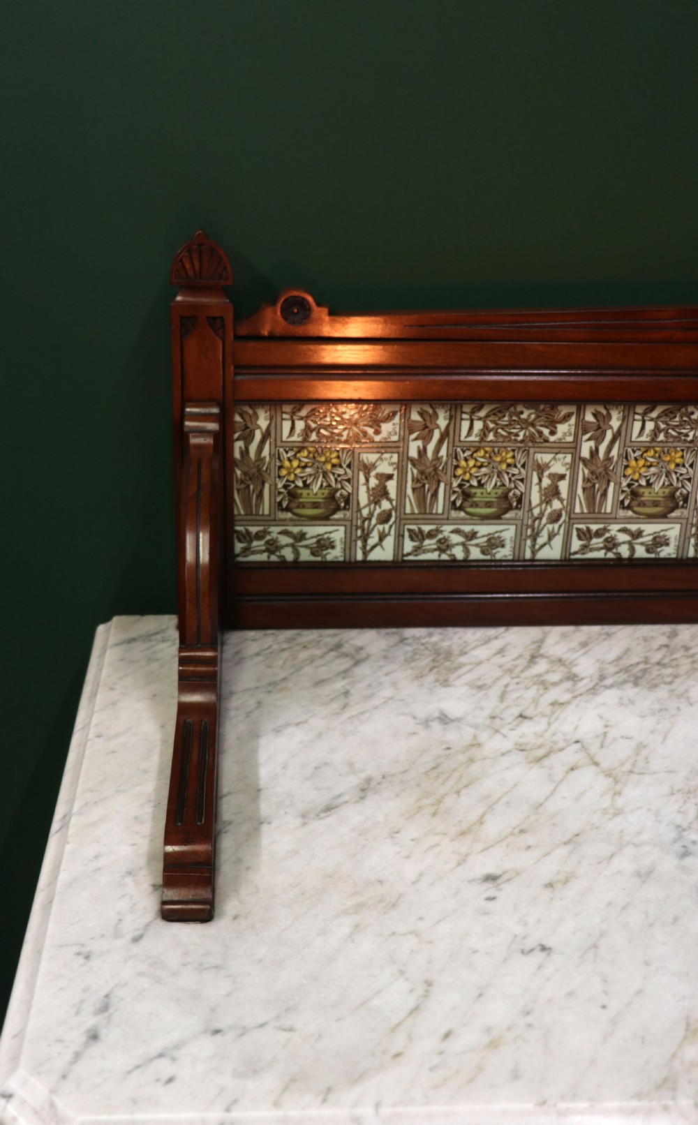A Victorian Aesthetic Movement mahogany washstand featuring a white marble top, a tiled gallery splashback with floral motifs, two pedestal cupboards, and a central drawer. View X