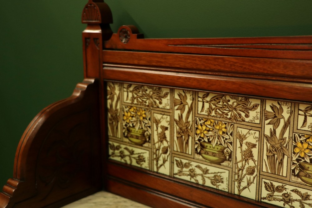 A Victorian Aesthetic Movement mahogany washstand featuring a white marble top, a tiled gallery splashback with floral motifs, two pedestal cupboards, and a central drawer. View XI