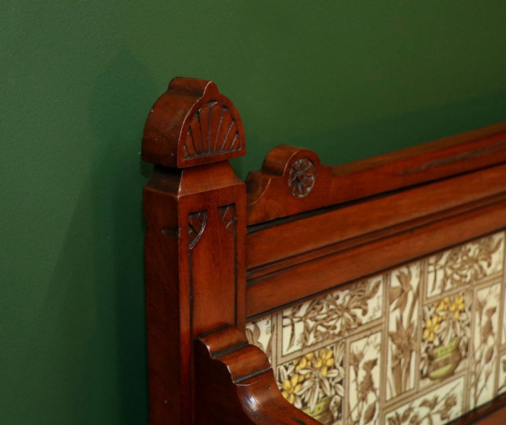 A Victorian Aesthetic Movement mahogany washstand featuring a white marble top, a tiled gallery splashback with floral motifs, two pedestal cupboards, and a central drawer. View XII