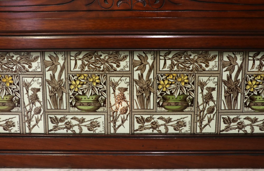 A Victorian Aesthetic Movement mahogany washstand featuring a white marble top, a tiled gallery splashback with floral motifs, two pedestal cupboards, and a central drawer. View XIV