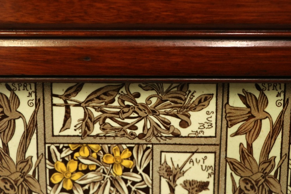 A Victorian Aesthetic Movement mahogany washstand featuring a white marble top, a tiled gallery splashback with floral motifs, two pedestal cupboards, and a central drawer. View XVI
