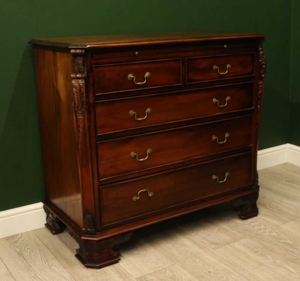 A solid mahogany bachelors chest featuring a pull-out slide, two upper drawers, three lower drawers, brass handles, and carved corner pilasters. View VII