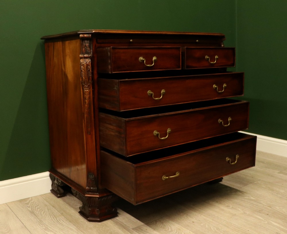 A solid mahogany bachelors chest featuring a pull-out slide, two upper drawers, three lower drawers, brass handles, and carved corner pilasters. View VIII