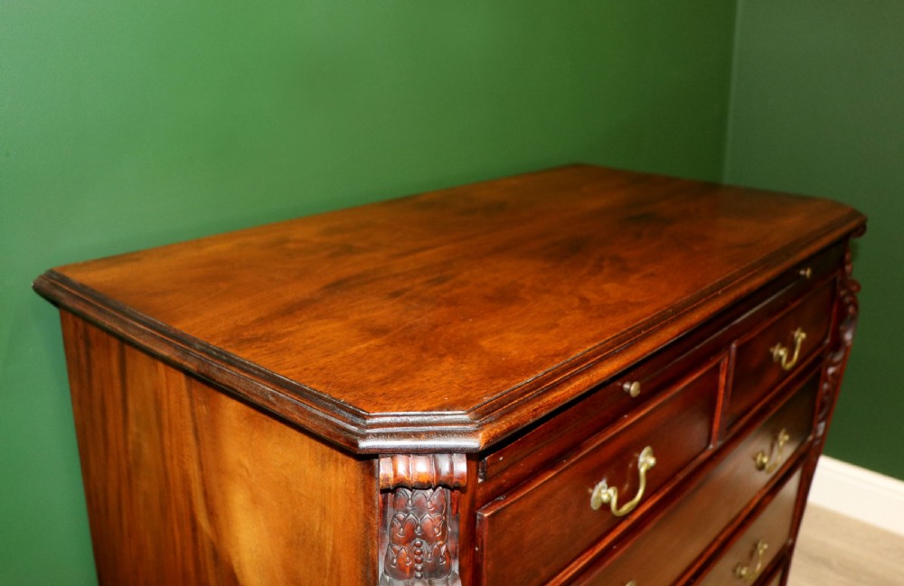 A solid mahogany bachelors chest featuring a pull-out slide, two upper drawers, three lower drawers, brass handles, and carved corner pilasters. View XI
