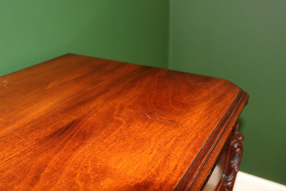 A solid mahogany bachelors chest featuring a pull-out slide, two upper drawers, three lower drawers, brass handles, and carved corner pilasters. View XII