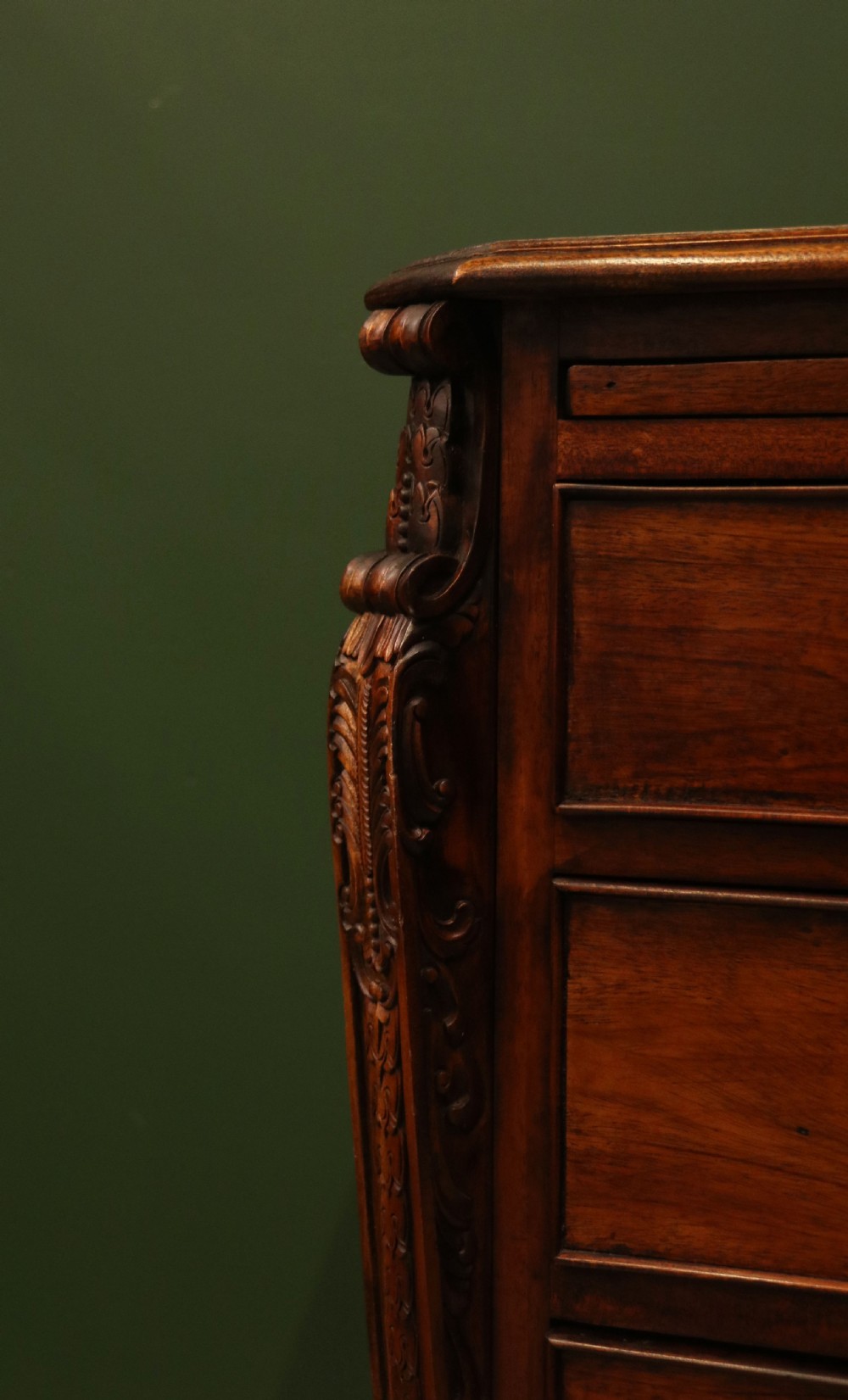 A solid mahogany bachelors chest featuring a pull-out slide, two upper drawers, three lower drawers, brass handles, and carved corner pilasters. View XVII