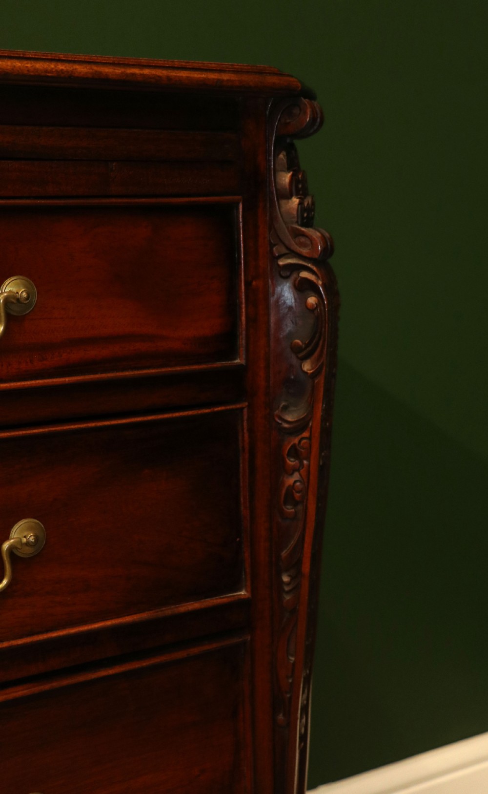 A solid mahogany bachelors chest featuring a pull-out slide, two upper drawers, three lower drawers, brass handles, and carved corner pilasters. View XX