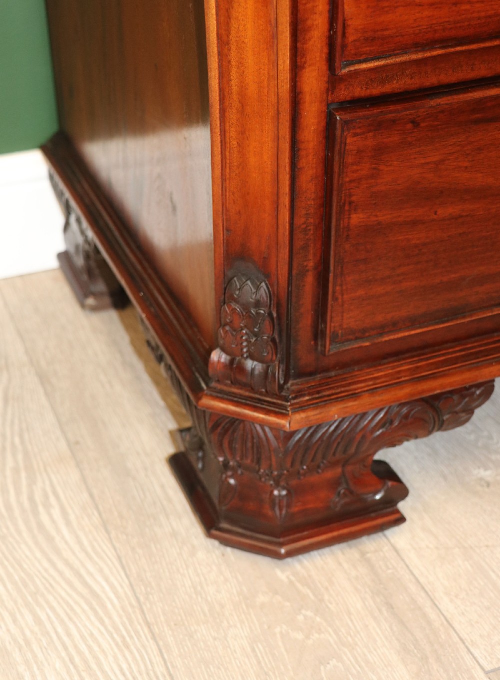 A solid mahogany bachelors chest featuring a pull-out slide, two upper drawers, three lower drawers, brass handles, and carved corner pilasters. View XXVI