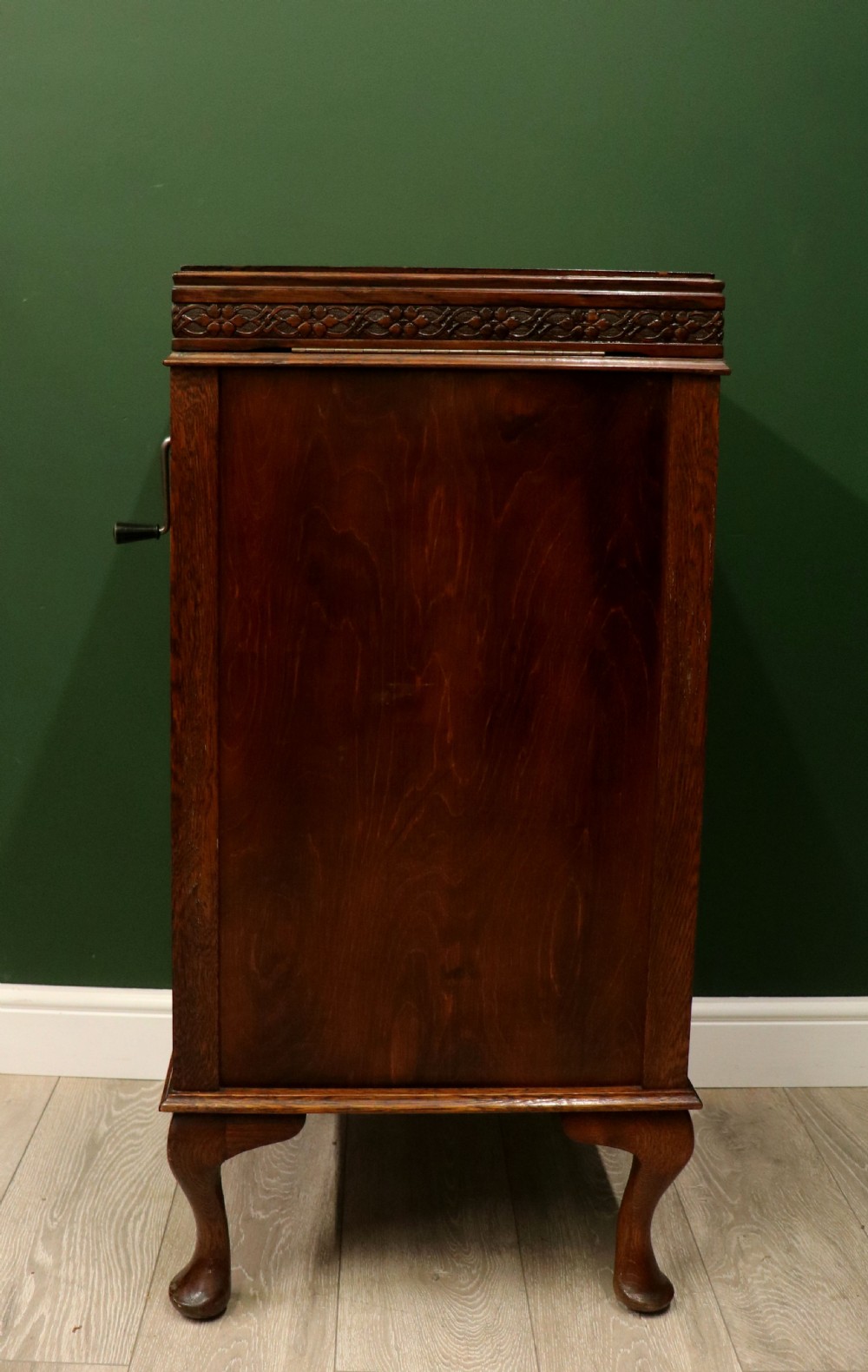 An upright dark oak parlour gramophone cabinet featuring cabriole legs, a hinged lid, carved rope detailing, and gothic arch fretwork grilles. View IX
