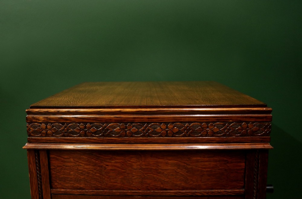 An upright dark oak parlour gramophone cabinet featuring cabriole legs, a hinged lid, carved rope detailing, and gothic arch fretwork grilles. View XIV