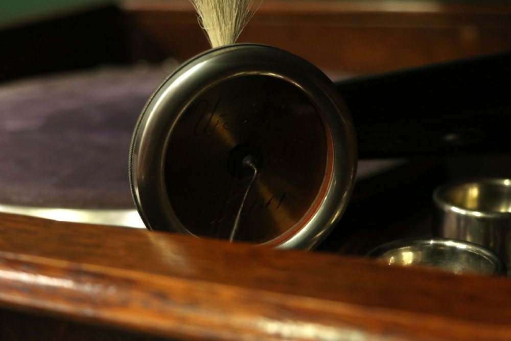 An upright dark oak parlour gramophone cabinet featuring cabriole legs, a hinged lid, carved rope detailing, and gothic arch fretwork grilles. View XIX