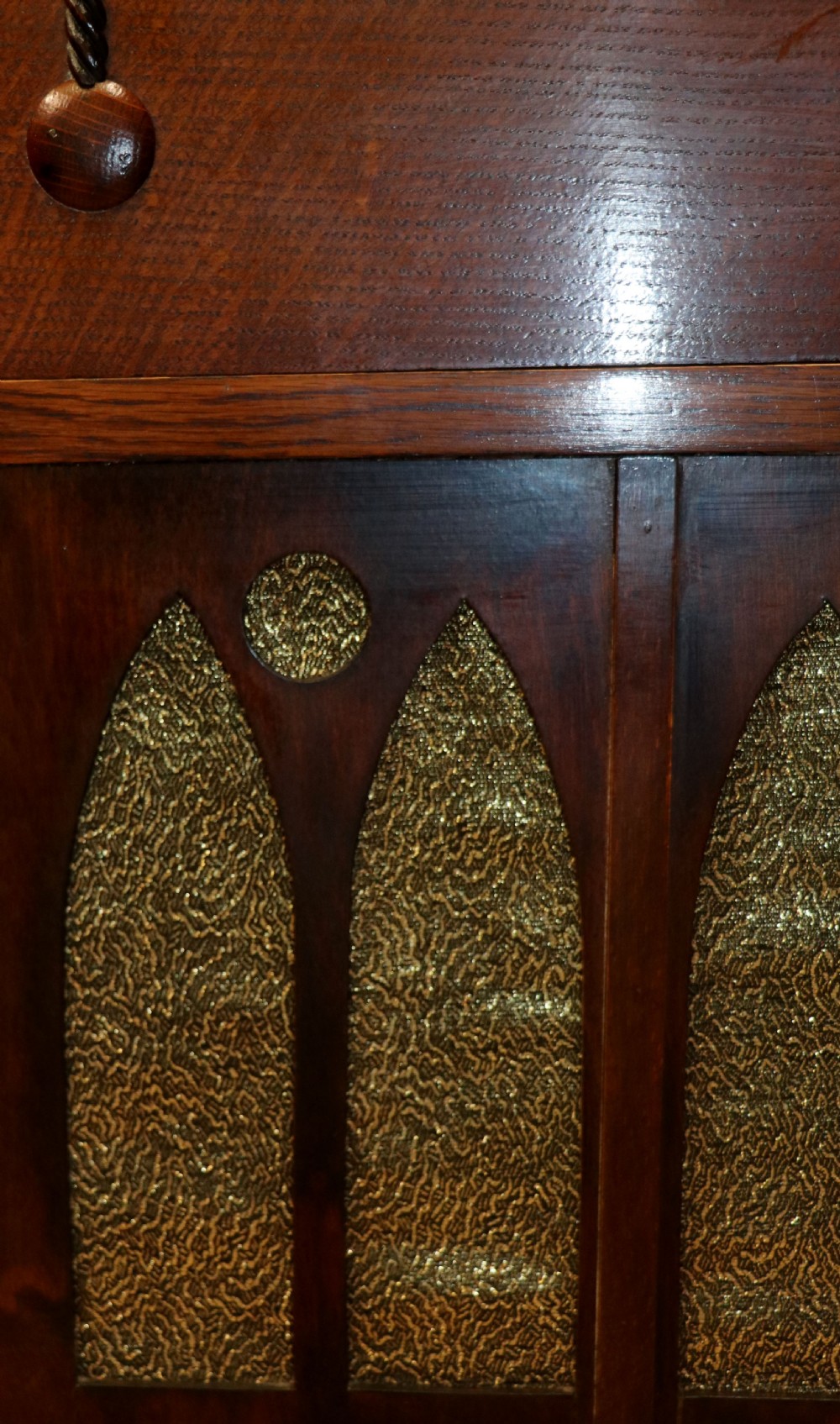 An upright dark oak parlour gramophone cabinet featuring cabriole legs, a hinged lid, carved rope detailing, and gothic arch fretwork grilles. View XXIX