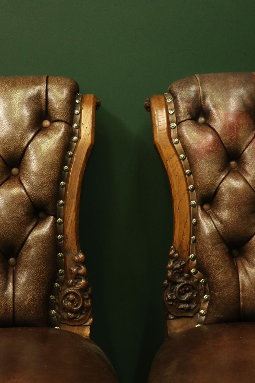 A pair of Victorian carved oak side chairs upholstered in deep-buttoned brown leather with brass studding and turned front legs on castors. View XIII
