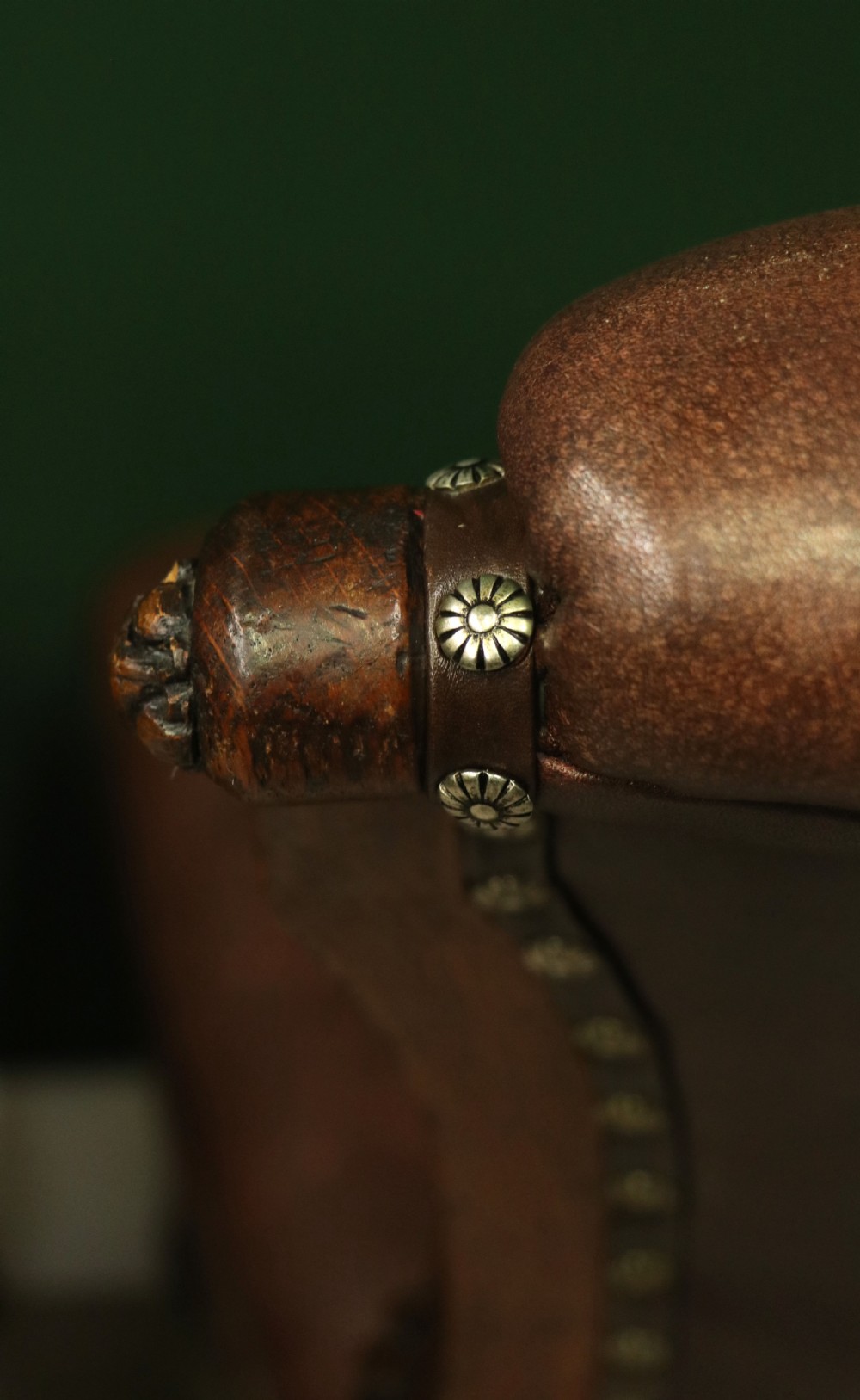 A pair of Victorian carved oak side chairs upholstered in deep-buttoned brown leather with brass studding and turned front legs on castors. View XX