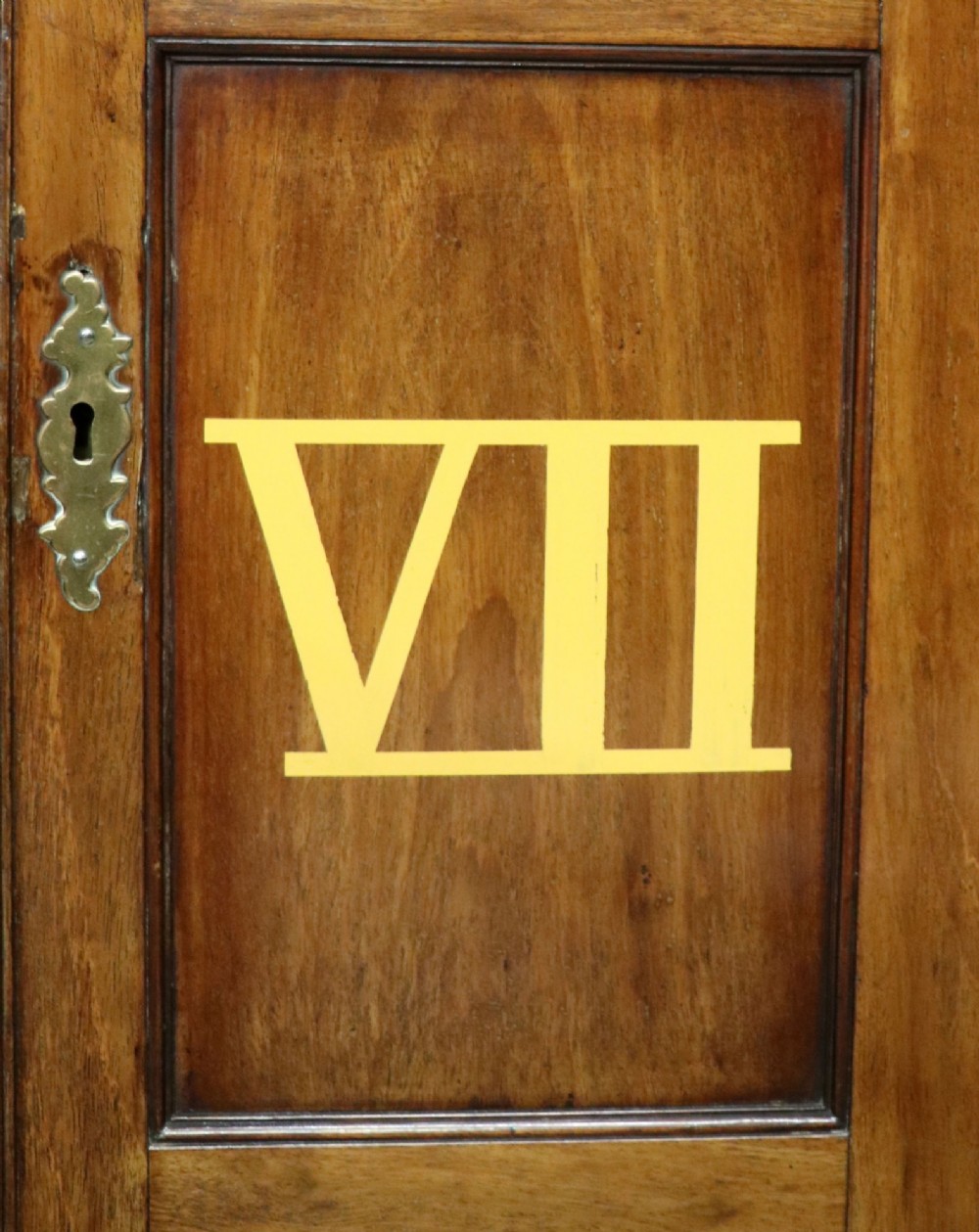 A George III mahogany wall-mounted corner cabinet with double panelled doors featuring painted yellow Roman numerals and a top frieze reading WHITEHALL 1212. View X