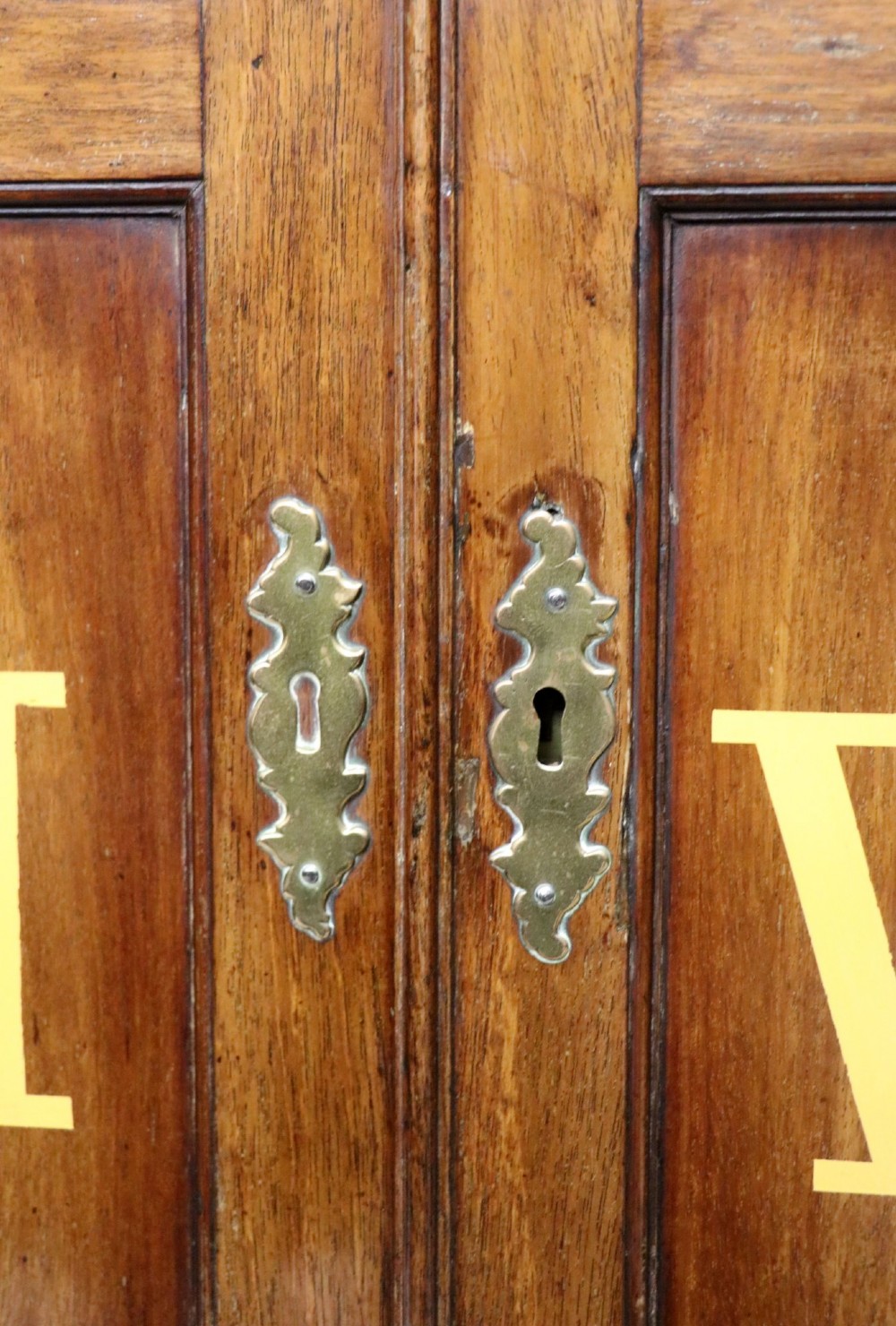 A George III mahogany wall-mounted corner cabinet with double panelled doors featuring painted yellow Roman numerals and a top frieze reading WHITEHALL 1212. View XI
