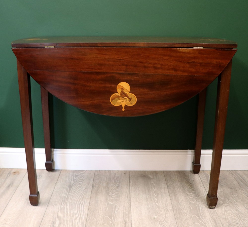 An Edwardian mahogany oval Pembroke table featuring drop leaves and inlaid clover motifs on tapered legs. View IV