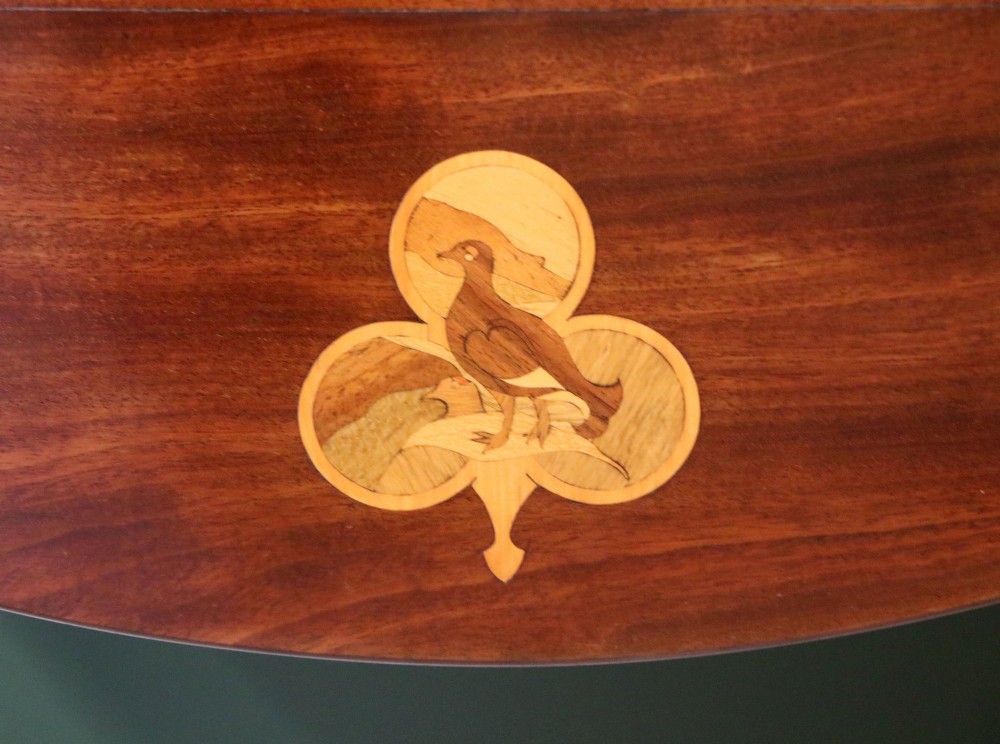 An Edwardian mahogany oval Pembroke table featuring drop leaves and inlaid clover motifs on tapered legs. View V