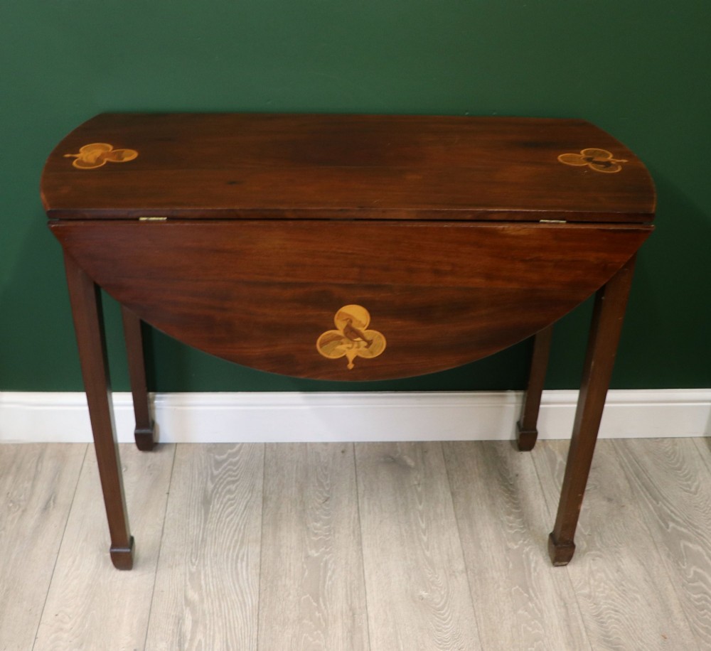 An Edwardian mahogany oval Pembroke table featuring drop leaves and inlaid clover motifs on tapered legs. View VI