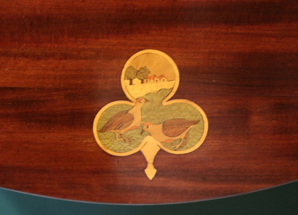 An Edwardian mahogany oval Pembroke table featuring drop leaves and inlaid clover motifs on tapered legs. View IX