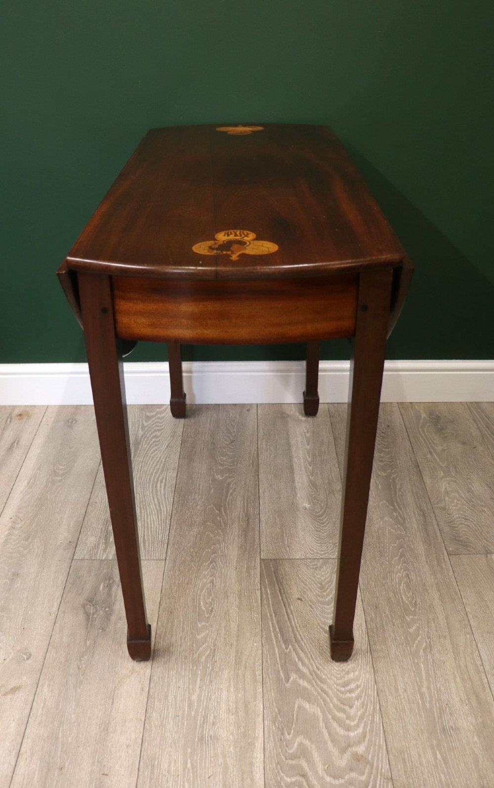 An Edwardian mahogany oval Pembroke table featuring drop leaves and inlaid clover motifs on tapered legs. View X