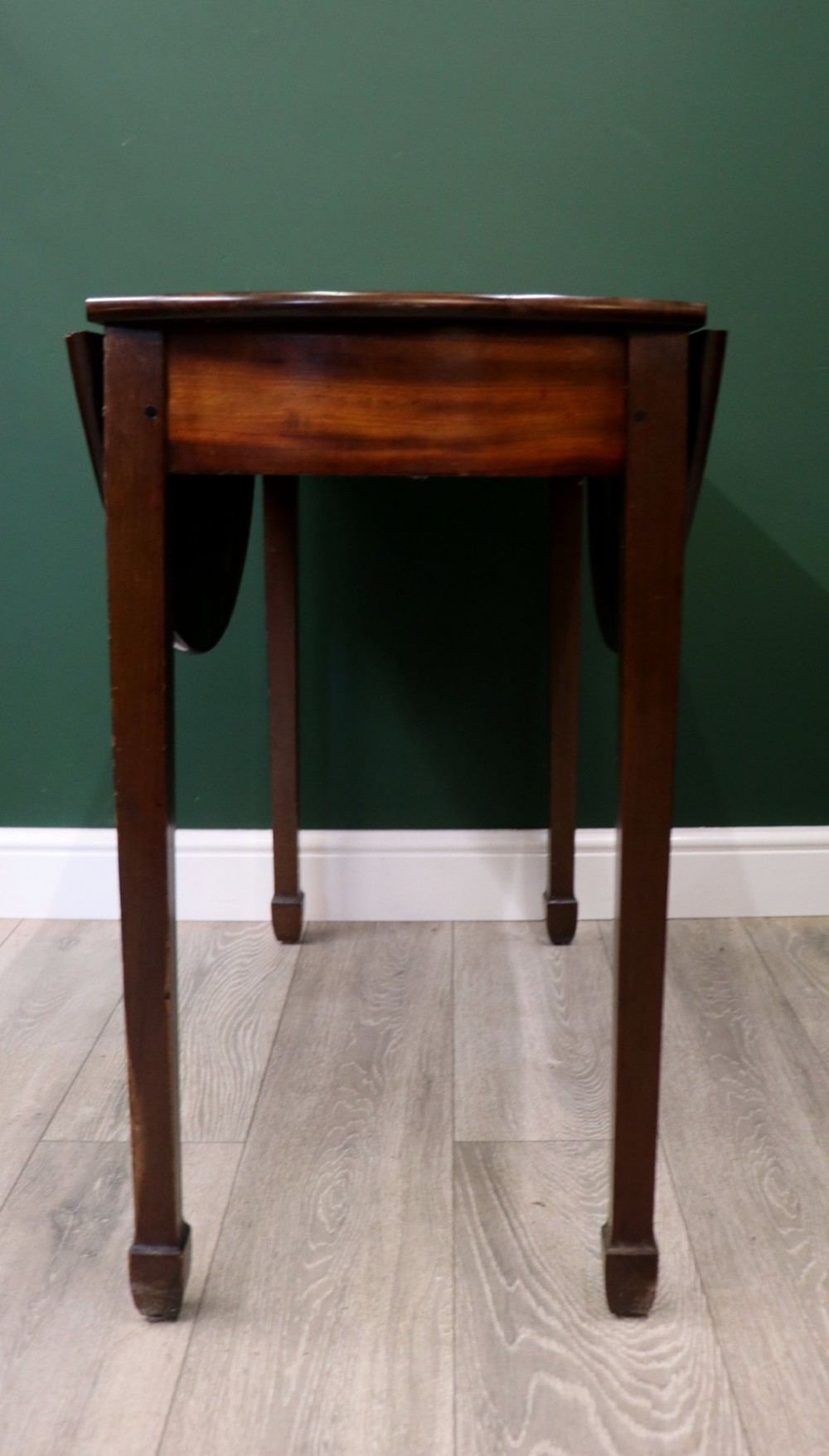 An Edwardian mahogany oval Pembroke table featuring drop leaves and inlaid clover motifs on tapered legs. View XI