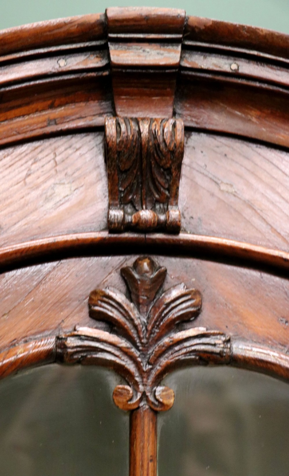 An early 20th-century floor-standing oak corner cabinet featuring an arched glazed upper door and a solid wood lower cupboard door. View VI