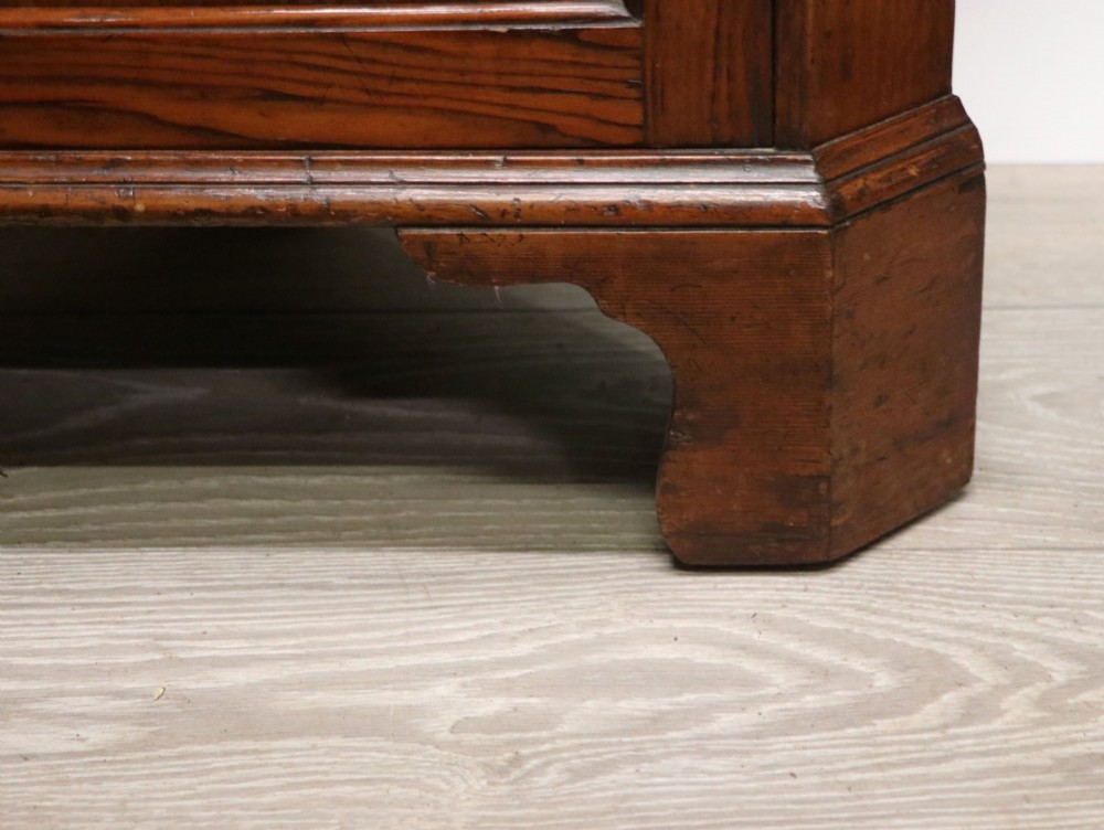 An early 20th-century floor-standing oak corner cabinet featuring an arched glazed upper door and a solid wood lower cupboard door. View XIII