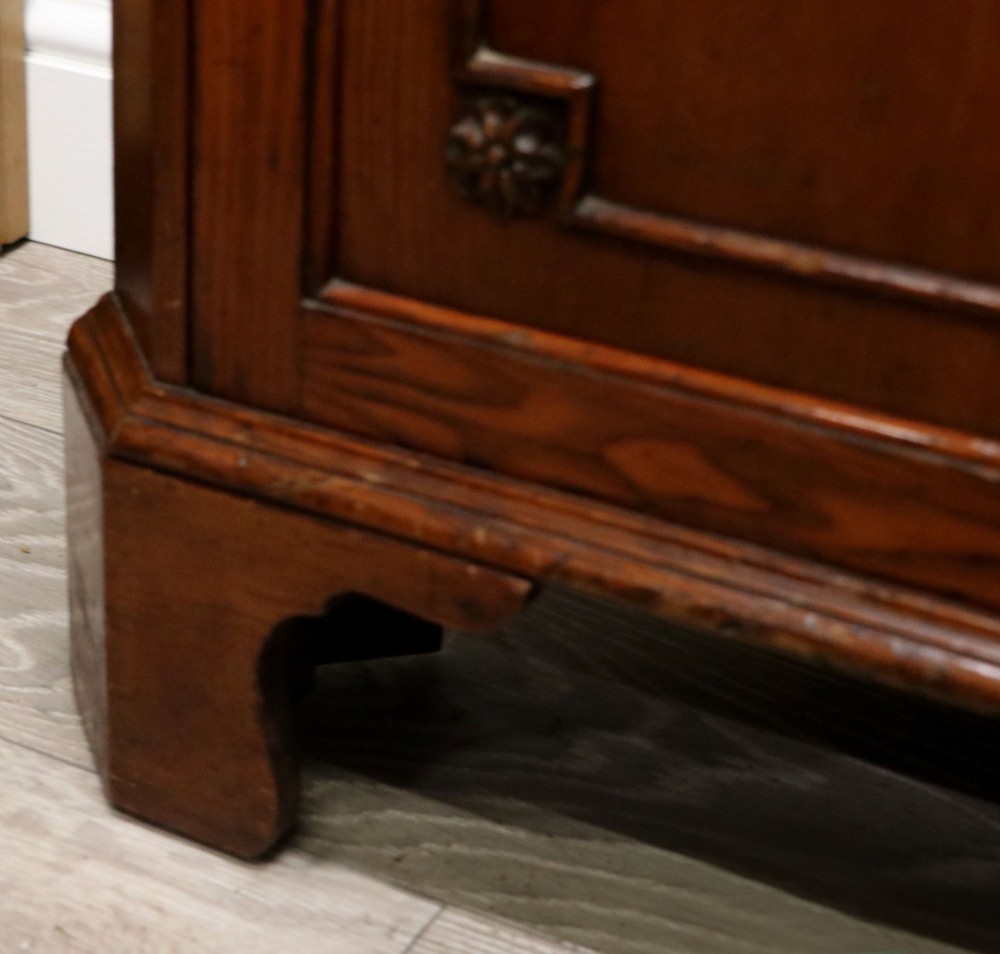 An early 20th-century floor-standing oak corner cabinet featuring an arched glazed upper door and a solid wood lower cupboard door. View XIV