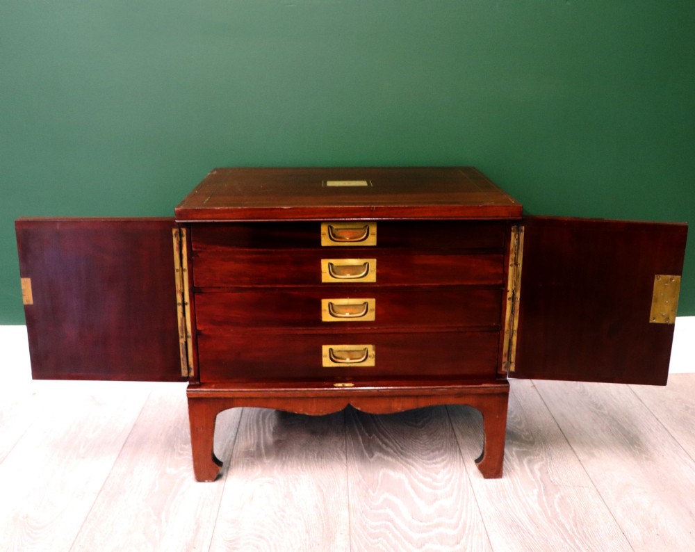 A mahogany campaign style collectors cabinet featuring geometric brass line inlays, twin front doors, a brass central keyhole, and shaped feet. View III