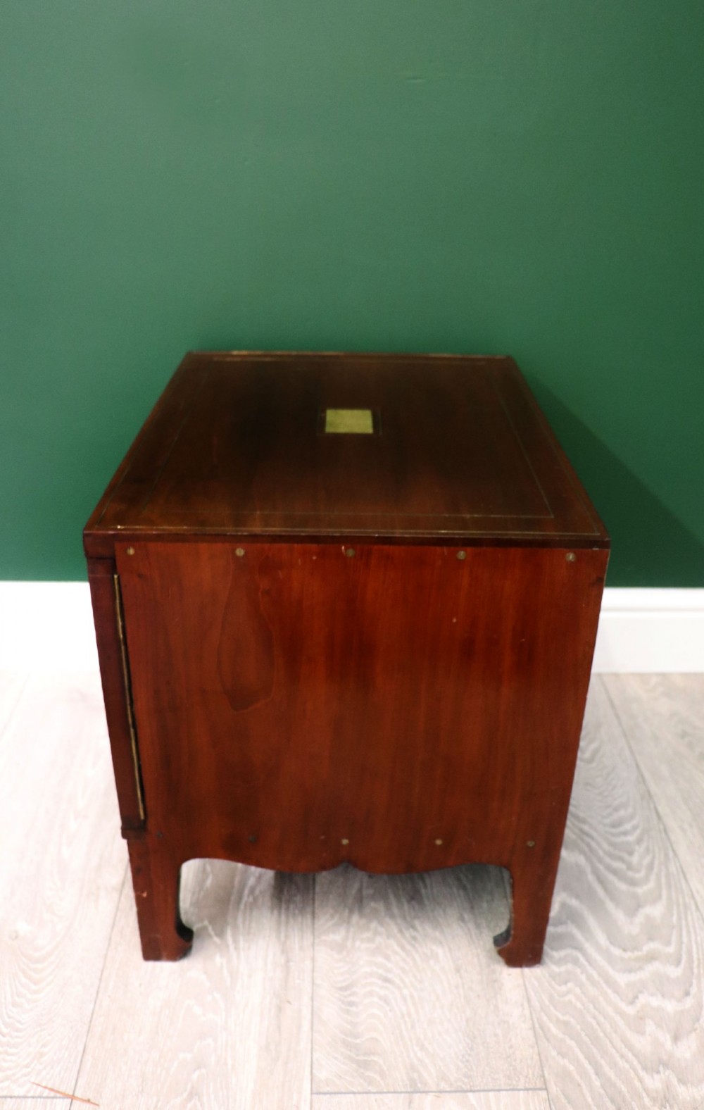 A mahogany campaign style collectors cabinet featuring geometric brass line inlays, twin front doors, a brass central keyhole, and shaped feet. View V
