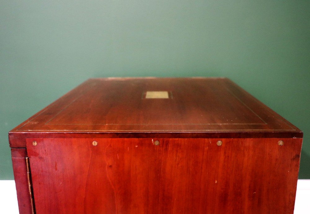 A mahogany campaign style collectors cabinet featuring geometric brass line inlays, twin front doors, a brass central keyhole, and shaped feet. View IX