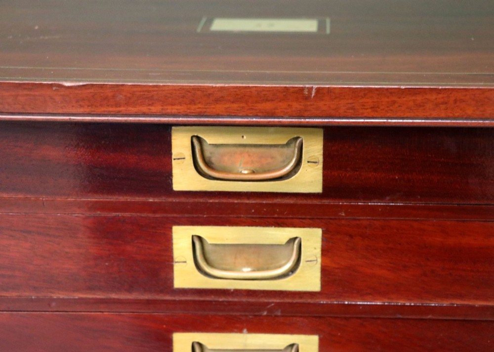 A mahogany campaign style collectors cabinet featuring geometric brass line inlays, twin front doors, a brass central keyhole, and shaped feet. View X