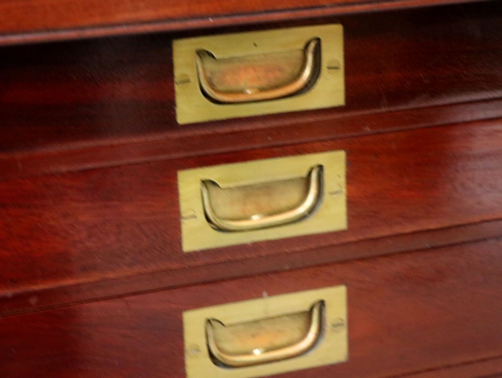 A mahogany campaign style collectors cabinet featuring geometric brass line inlays, twin front doors, a brass central keyhole, and shaped feet. View XI