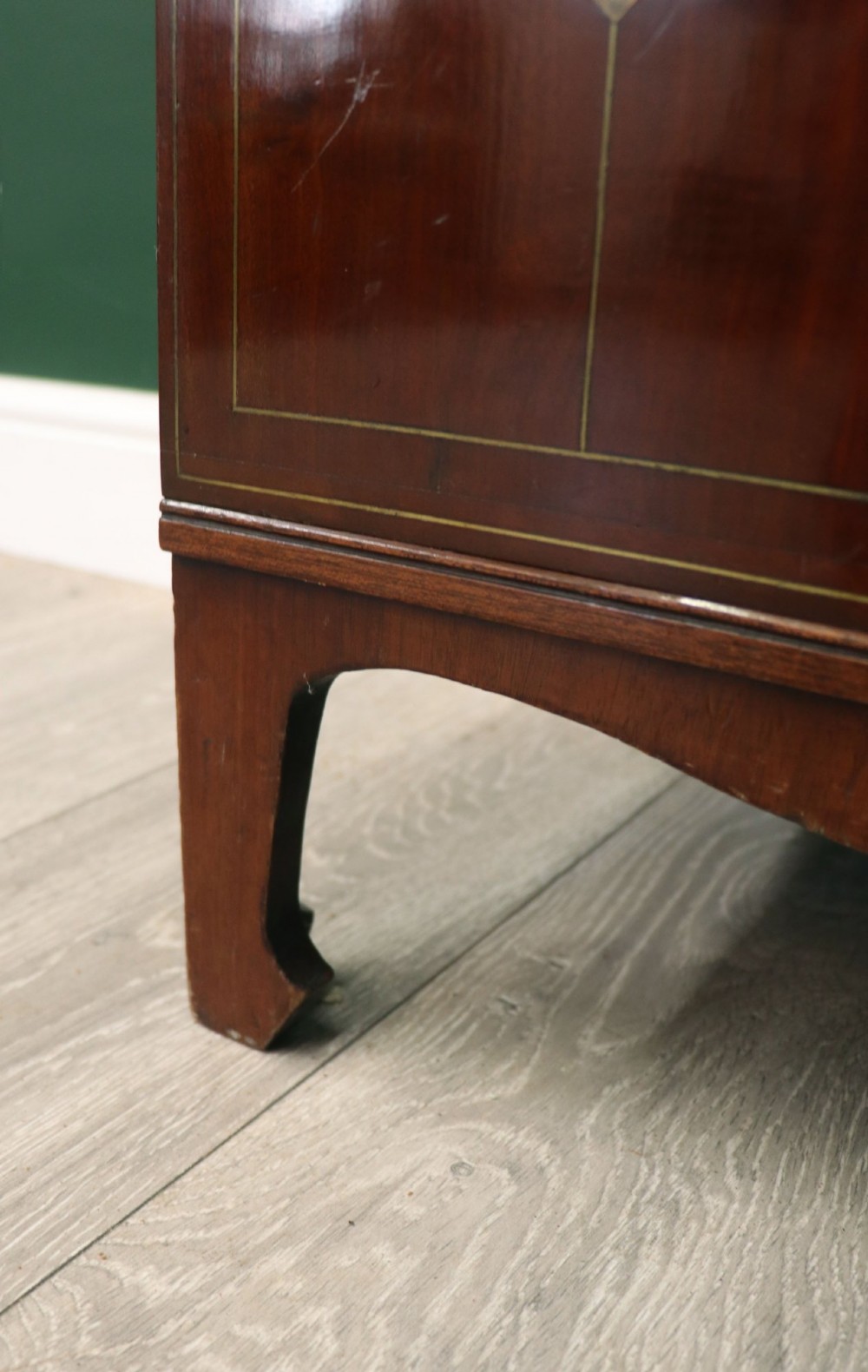 A mahogany campaign style collectors cabinet featuring geometric brass line inlays, twin front doors, a brass central keyhole, and shaped feet. View XV