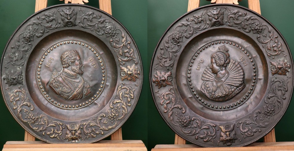Pair of circular relief-embossed copper wall chargers depicting profile portraits of King Henry IV and Queen Marie de Medicis surrounded by floral and mask borders. View II
