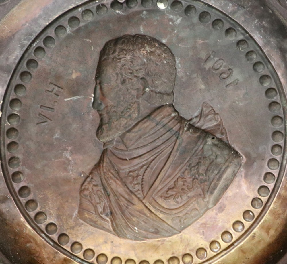 Pair of circular relief-embossed copper wall chargers depicting profile portraits of King Henry IV and Queen Marie de Medicis surrounded by floral and mask borders. View VII