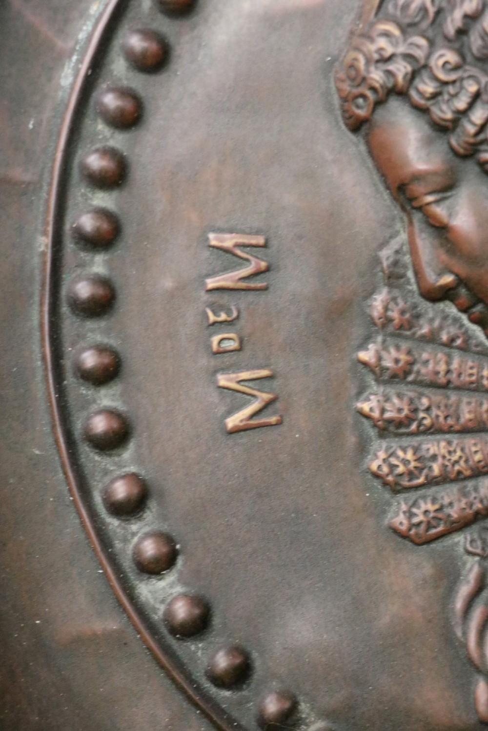 Pair of circular relief-embossed copper wall chargers depicting profile portraits of King Henry IV and Queen Marie de Medicis surrounded by floral and mask borders. View XI